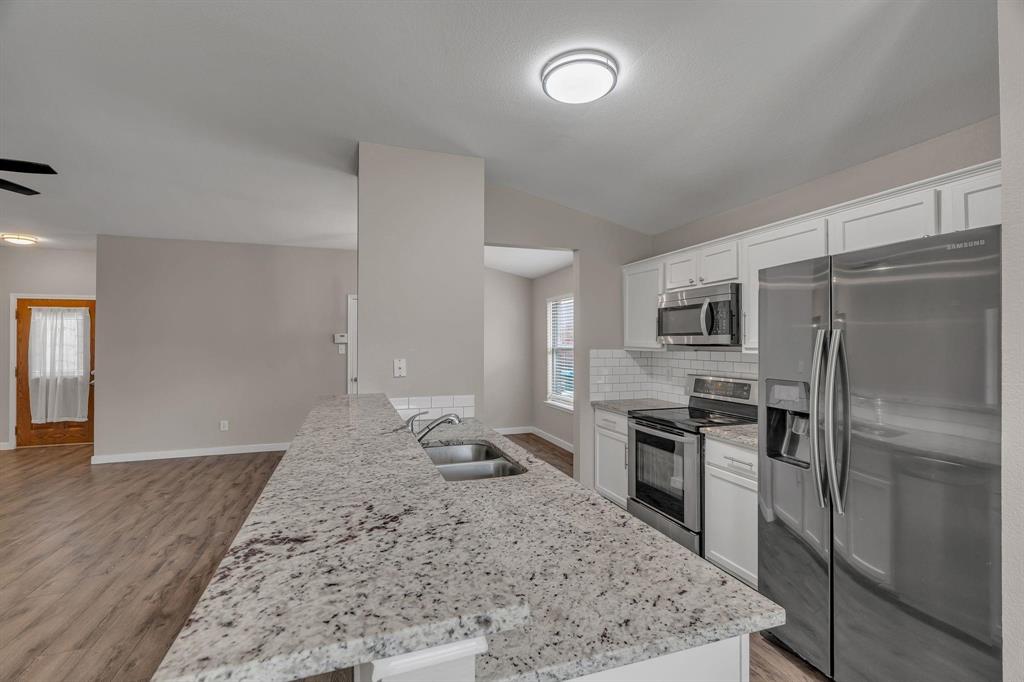 3920 Cane River Road Fort Worth, TX 76244 - Photo 3 of 22 a kitchen with a refrigerator and a sink