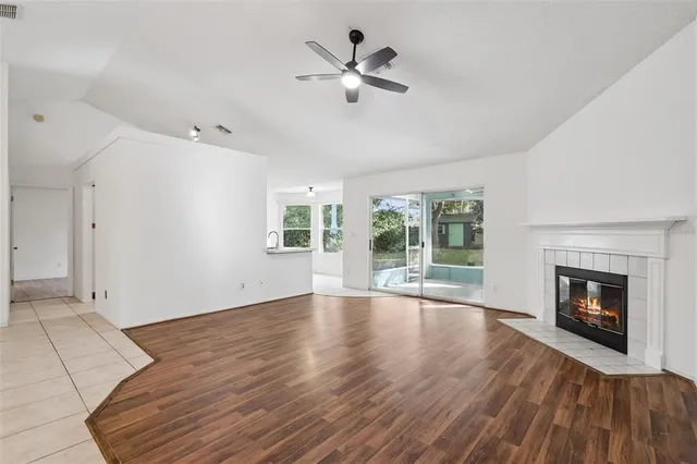wooden floor fireplace and windows in an empty room