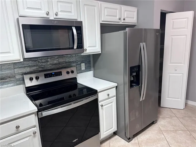 a kitchen with granite countertop a refrigerator stove and microwave