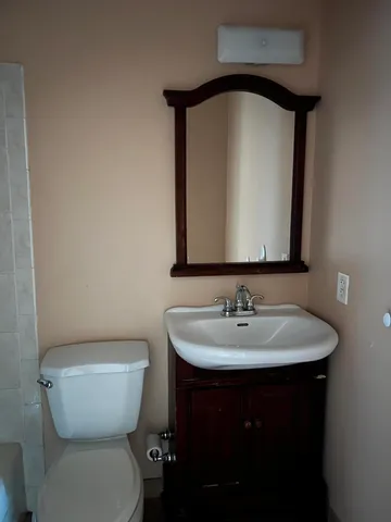 a bathroom with a toilet sink and mirror