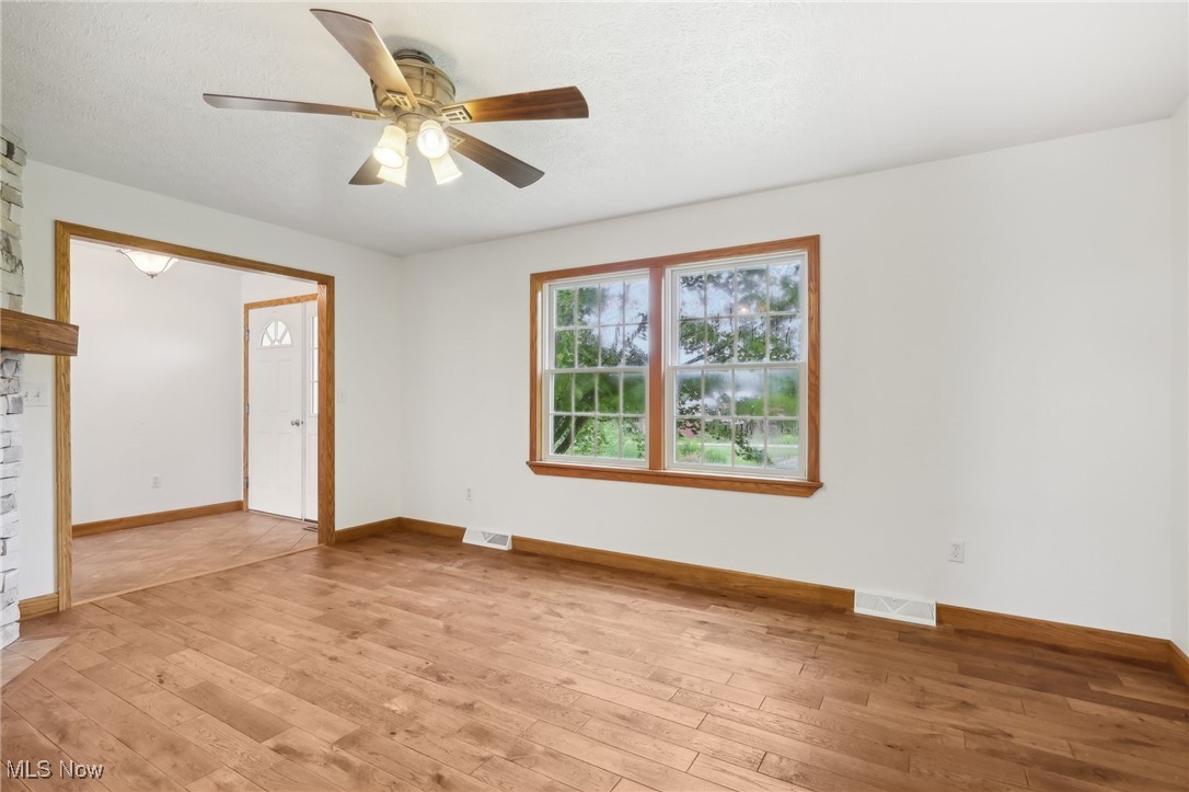 476 Garrison Road Ashtabula, OH 44004 - Photo 31 of 50 Unfurnished living room featuring a textured ceiling, ceiling fan, and light hardwood / wood-style floors
