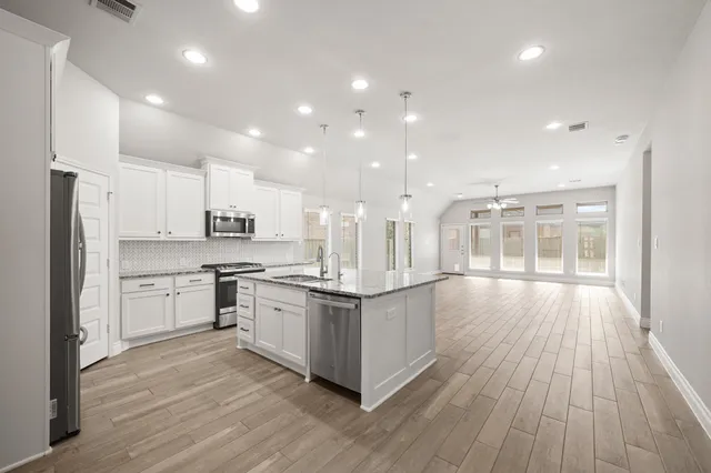 a kitchen with stainless steel appliances a stove top oven and cabinets
