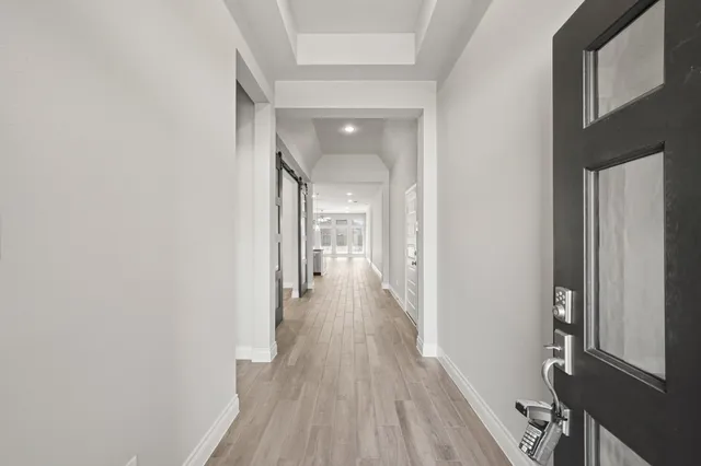 a view of a hallway with wooden floor and staircase