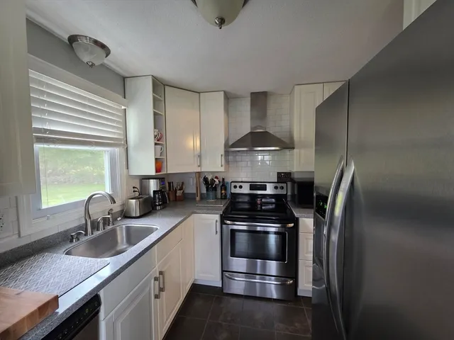 a kitchen with stainless steel appliances granite countertop a sink and cabinets