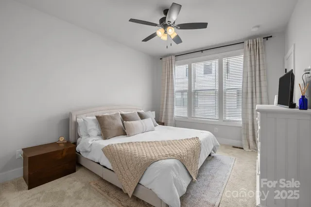 a bedroom with a large bed and a chandelier