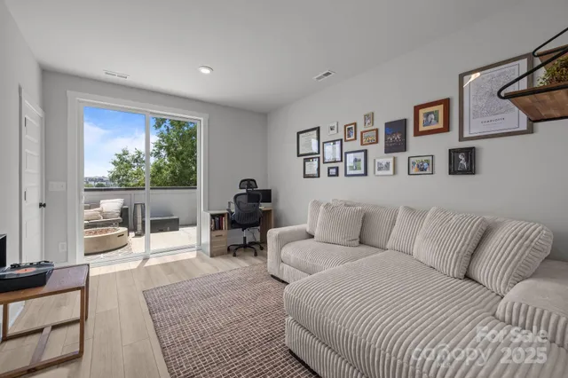 a living room with furniture large window and book shelf