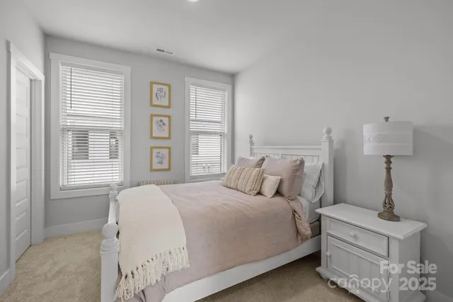a bedroom with a bed a window and potted plant