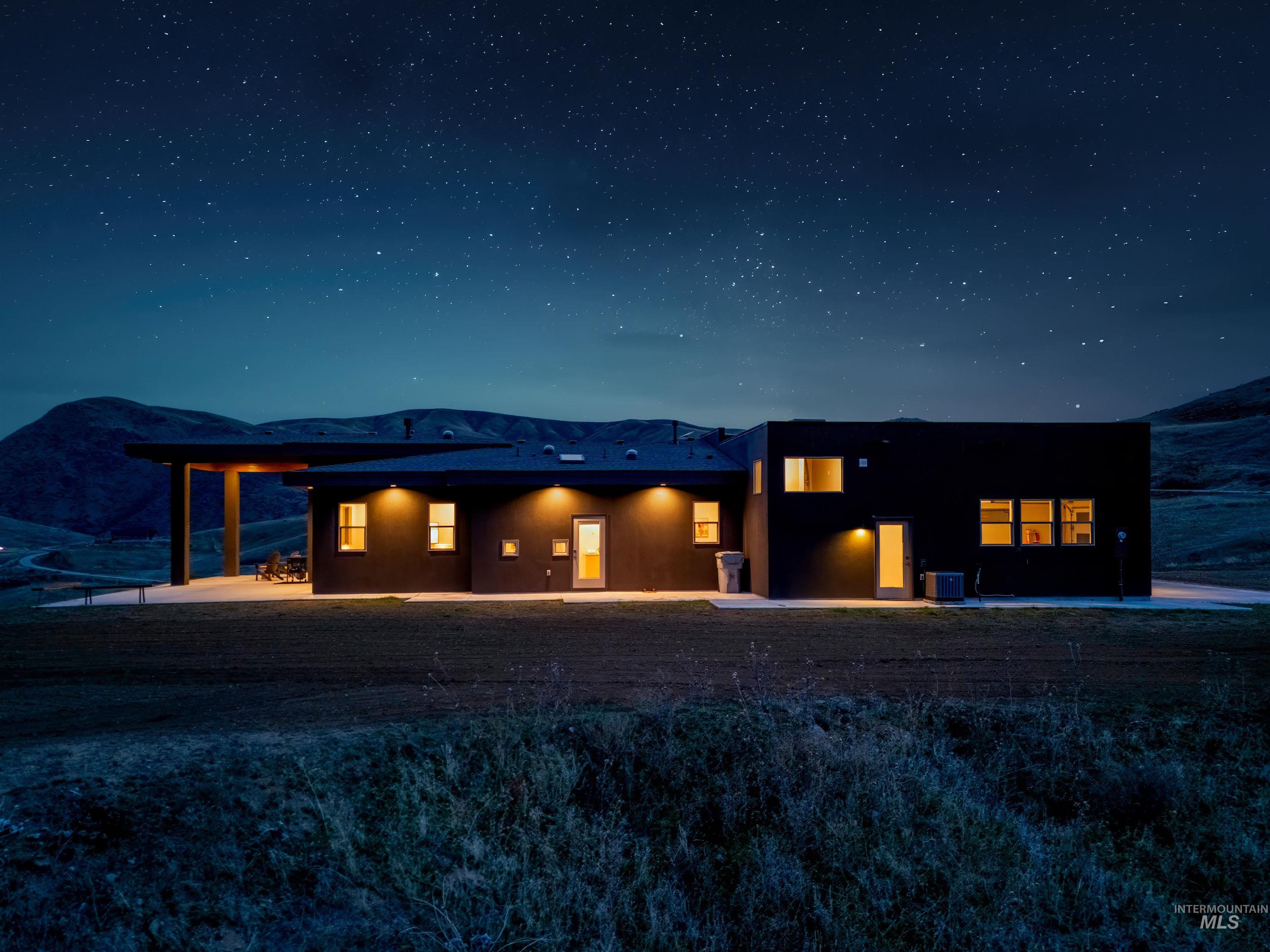 170 Summit Ridge Road Horseshoe Bend, ID 83629 - Photo 46 of 50 Back of house at night with stucco siding and a patio area