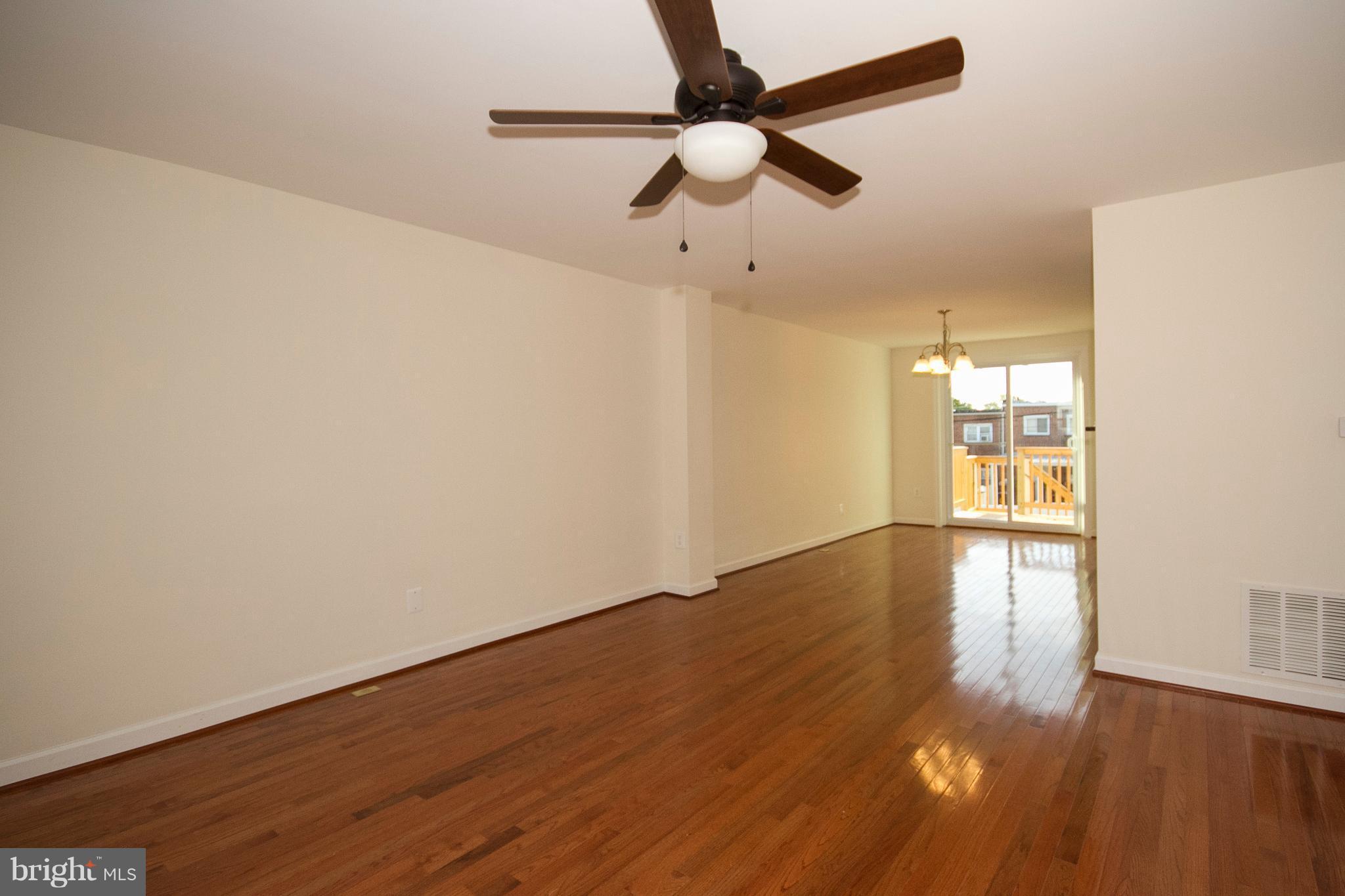 1381 Deanwood Road Baltimore, MD 21234 - Photo 2 of 27 a view of an empty room with wooden floor and a window