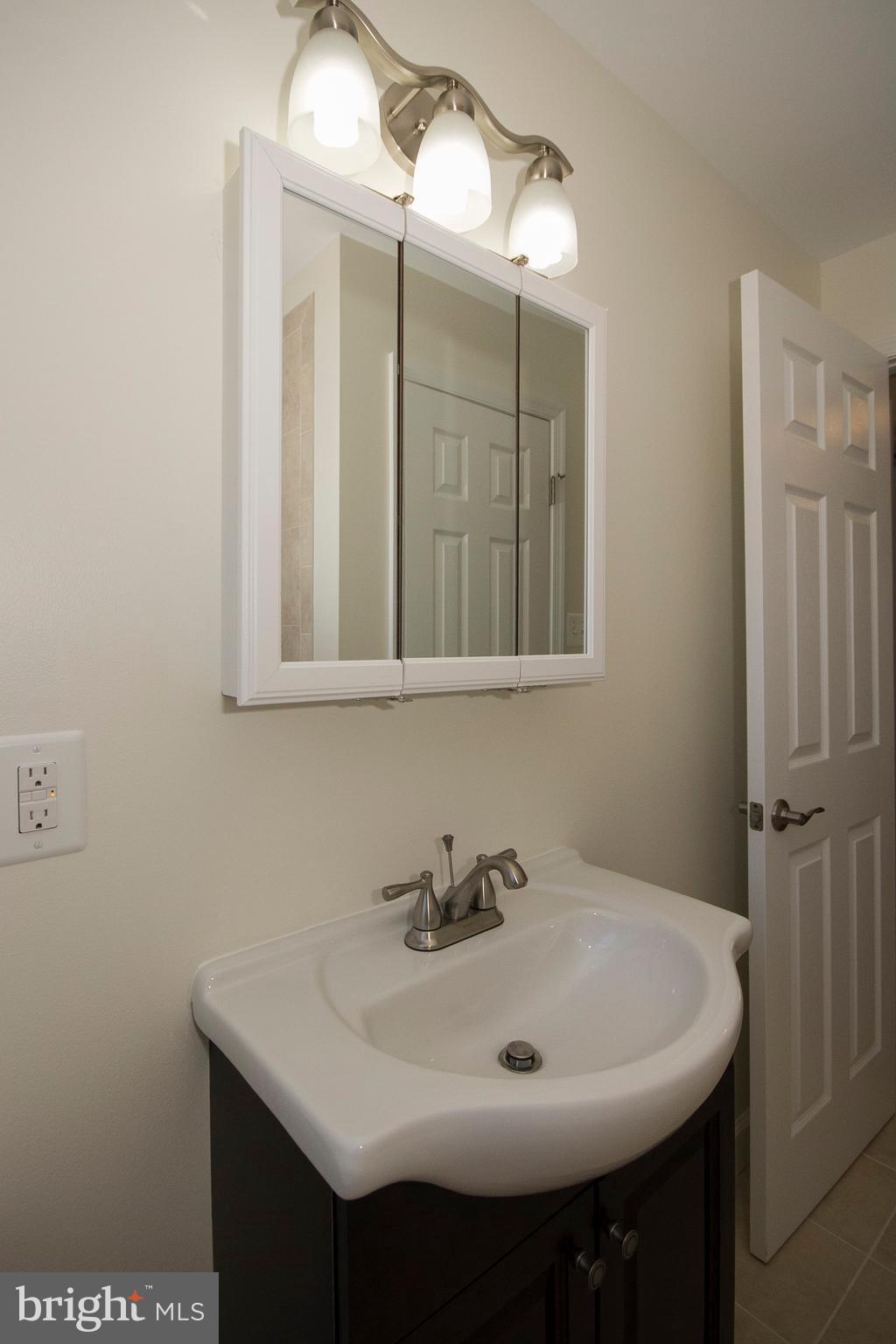 1381 Deanwood Road Baltimore, MD 21234 - Photo 22 of 27 a bathroom with a sink and a mirror