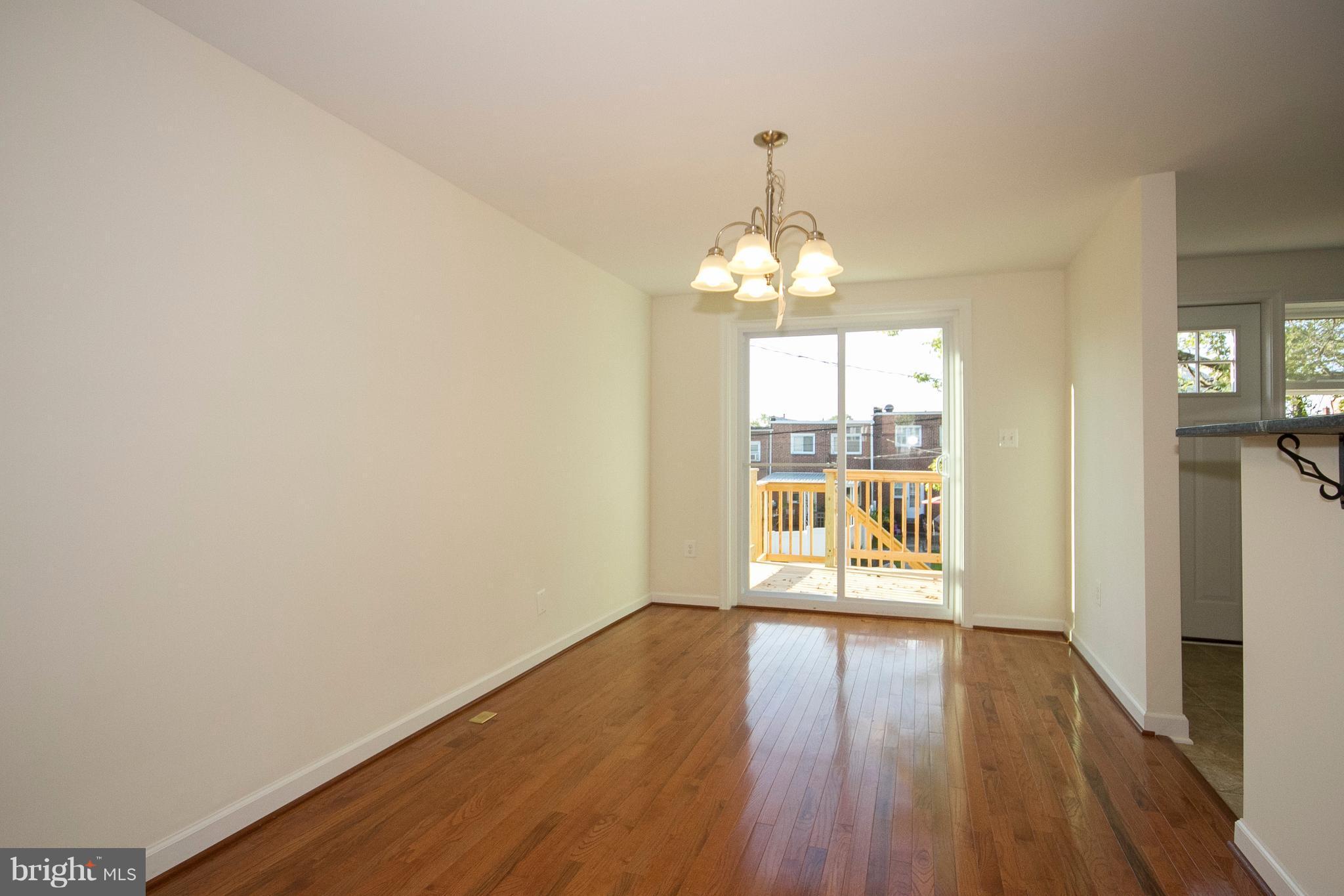 1381 Deanwood Road Baltimore, MD 21234 - Photo 5 of 27 a view of an empty room with wooden floor and a window