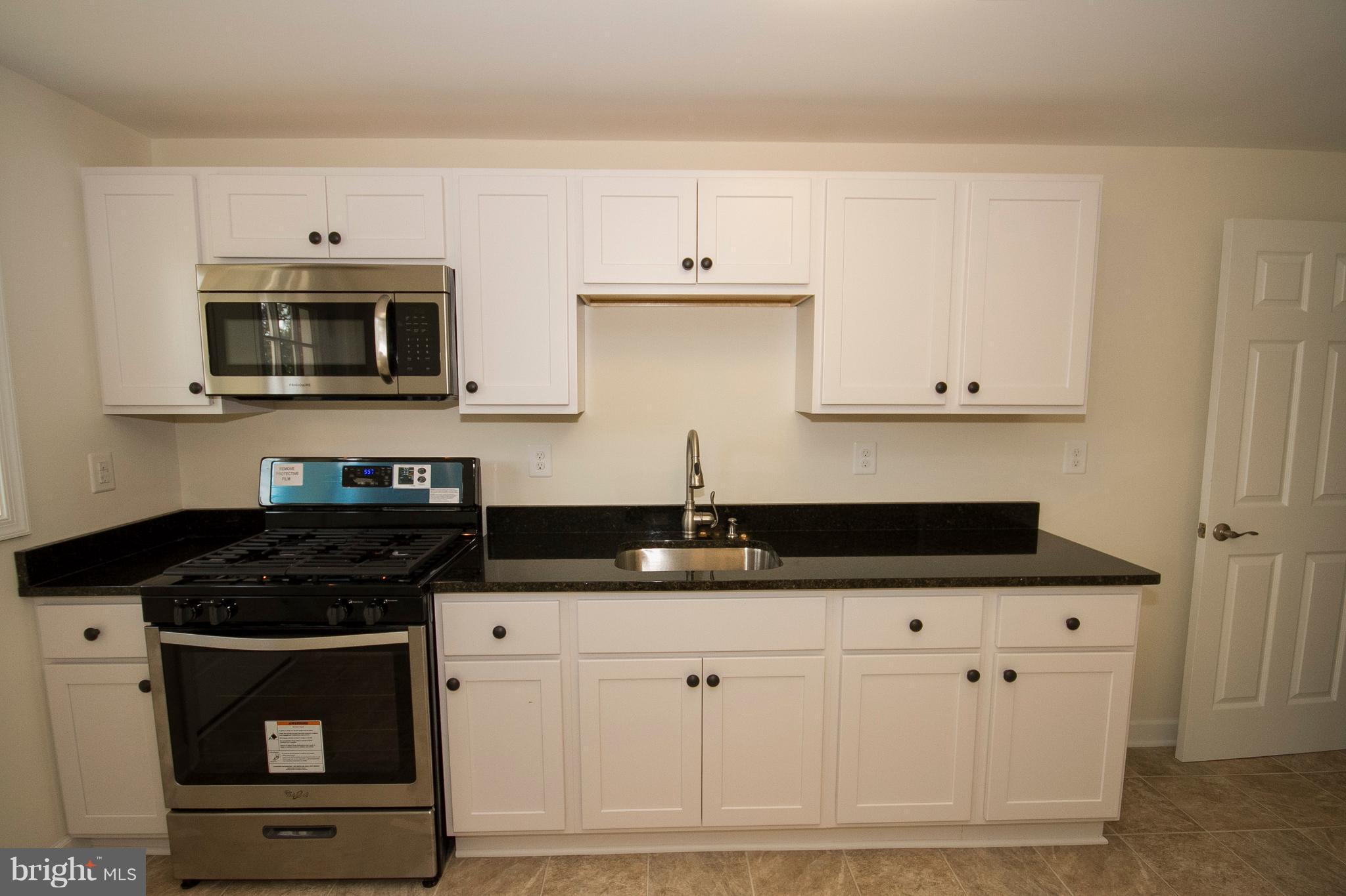 1381 Deanwood Road Baltimore, MD 21234 - Photo 8 of 27 a kitchen with granite countertop white cabinets and black appliances