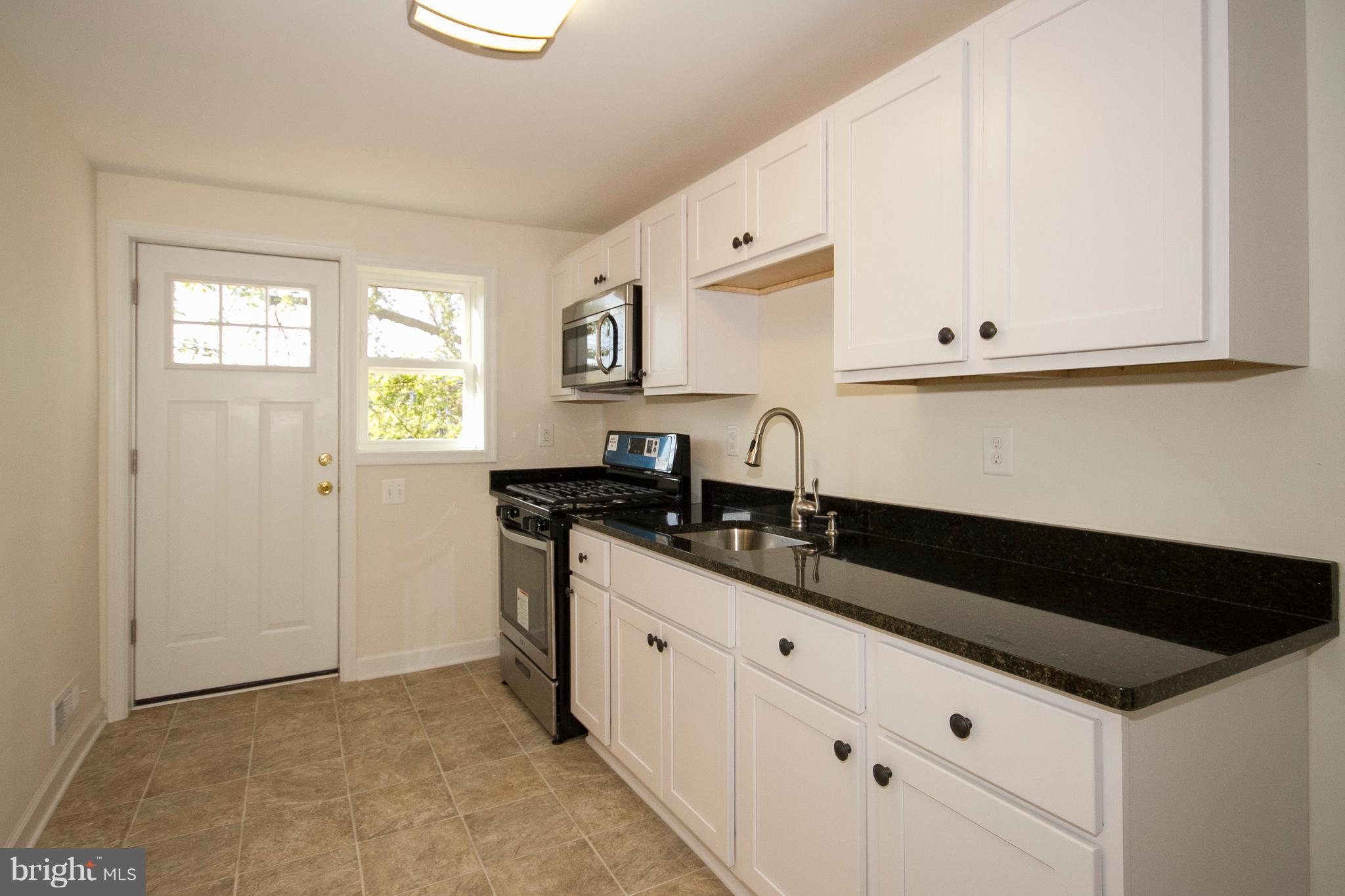 1381 Deanwood Road Baltimore, MD 21234 - Photo 9 of 27 a kitchen with granite countertop a sink and a stove