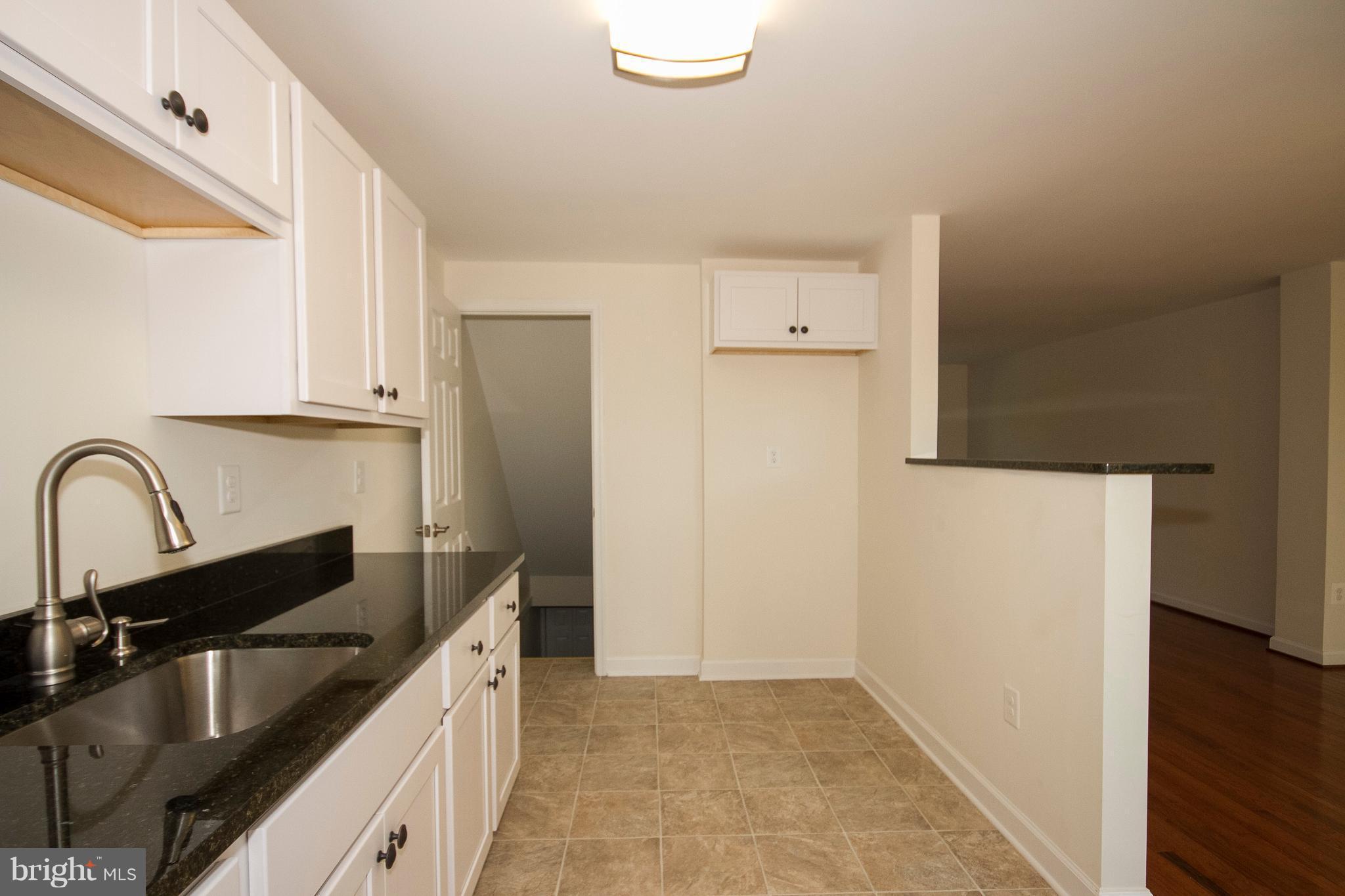 1381 Deanwood Road Baltimore, MD 21234 - Photo 10 of 27 a kitchen with a refrigerator sink and cabinets