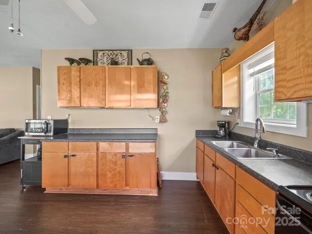 a kitchen with stainless steel appliances granite countertop a sink stove and cabinets