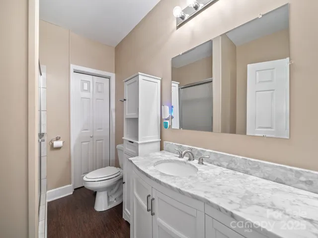 a bathroom with a granite countertop sink toilet and shower