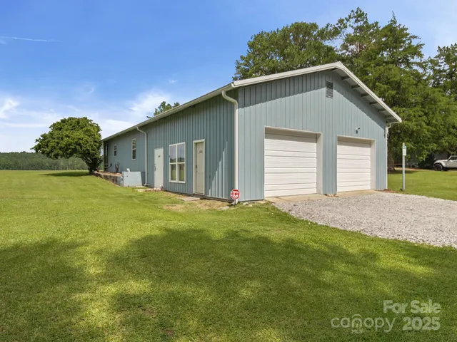 a front view of house with yard and trees in the background