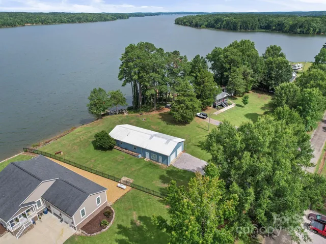 an aerial view of a house with a yard and lake view