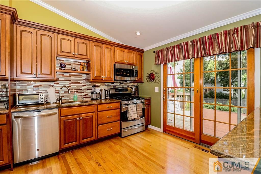66 Harmon Road Edison, NJ 08837 - Photo 11 of 25 a kitchen with stainless steel appliances granite countertop a stove a sink and a microwave