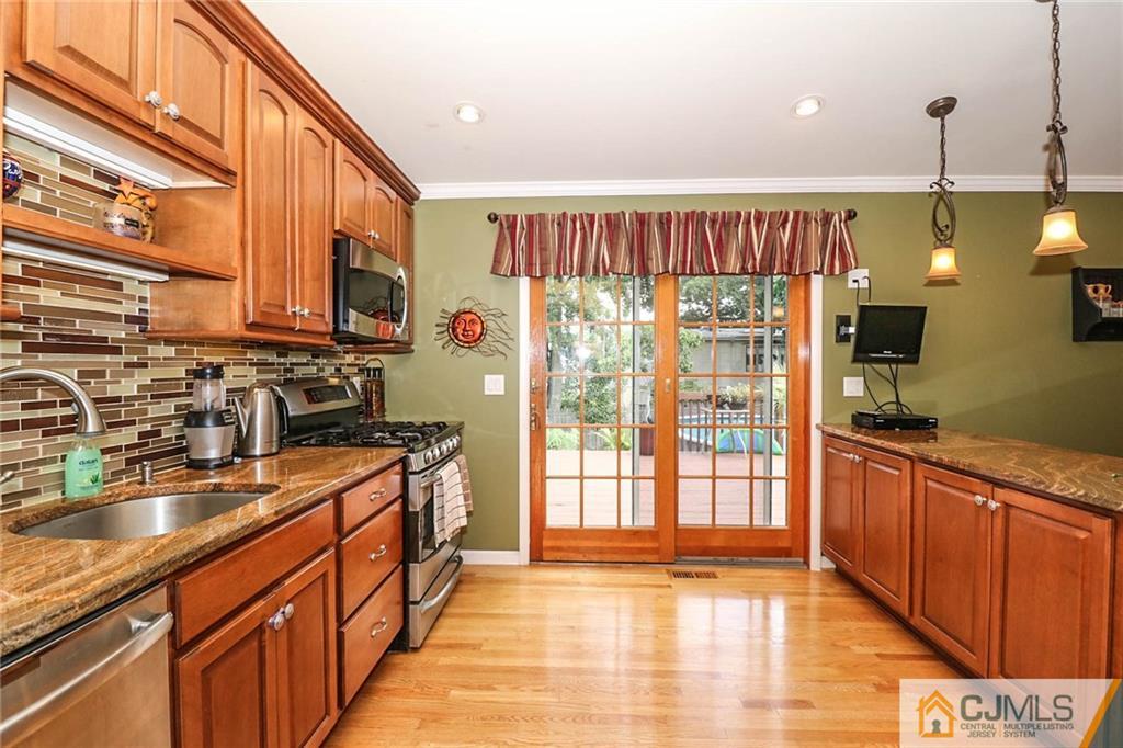 66 Harmon Road Edison, NJ 08837 - Photo 13 of 25 a kitchen with stainless steel appliances granite countertop a sink a stove and a wooden floors