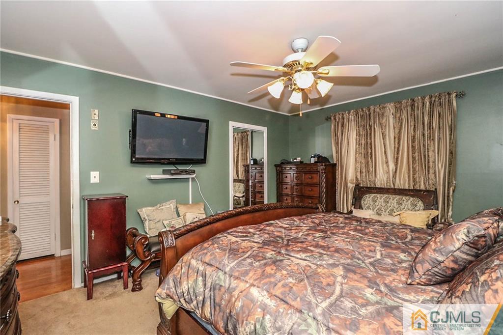 66 Harmon Road Edison, NJ 08837 - Photo 15 of 25 a bedroom with a bed and a flat tv screen on dresser
