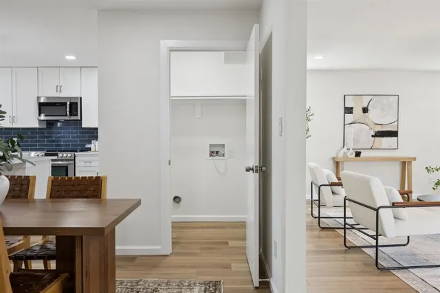 a kitchen with stainless steel appliances a dining table chairs and granite counter tops