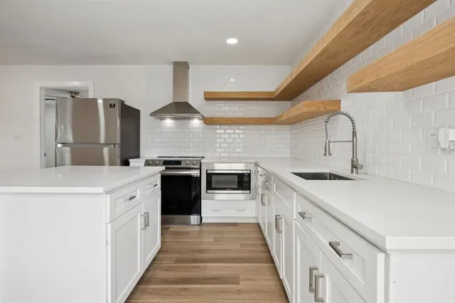 a kitchen with stainless steel appliances a sink stove and cabinets