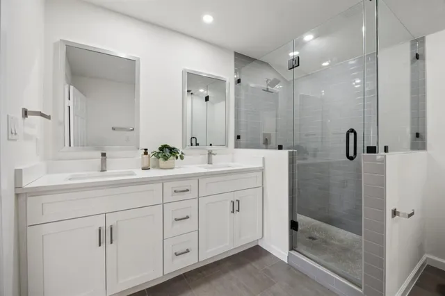 a bathroom with double sink and a shower