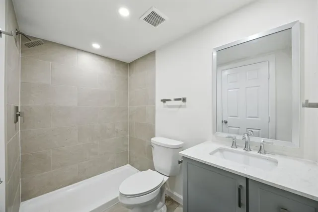 a bathroom with a granite countertop sink toilet and shower