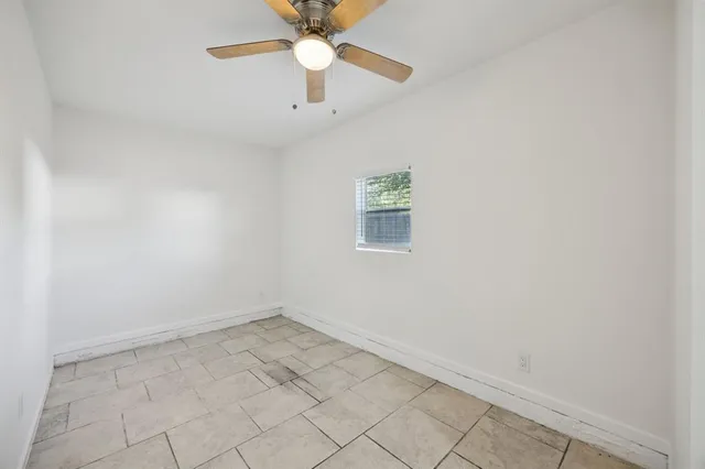 an empty room with a window and a fan