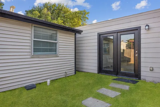 a view of a backyard with plants and a grill
