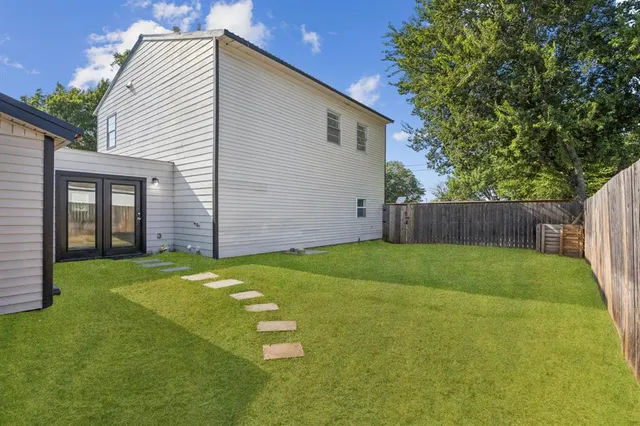 a view of a backyard with a garden and tree