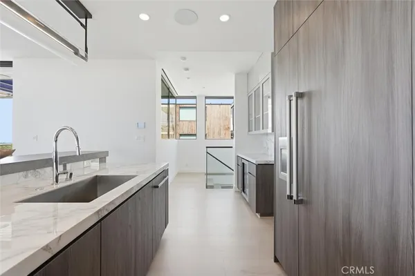 a kitchen with stainless steel appliances granite countertop a sink refrigerator and cabinets