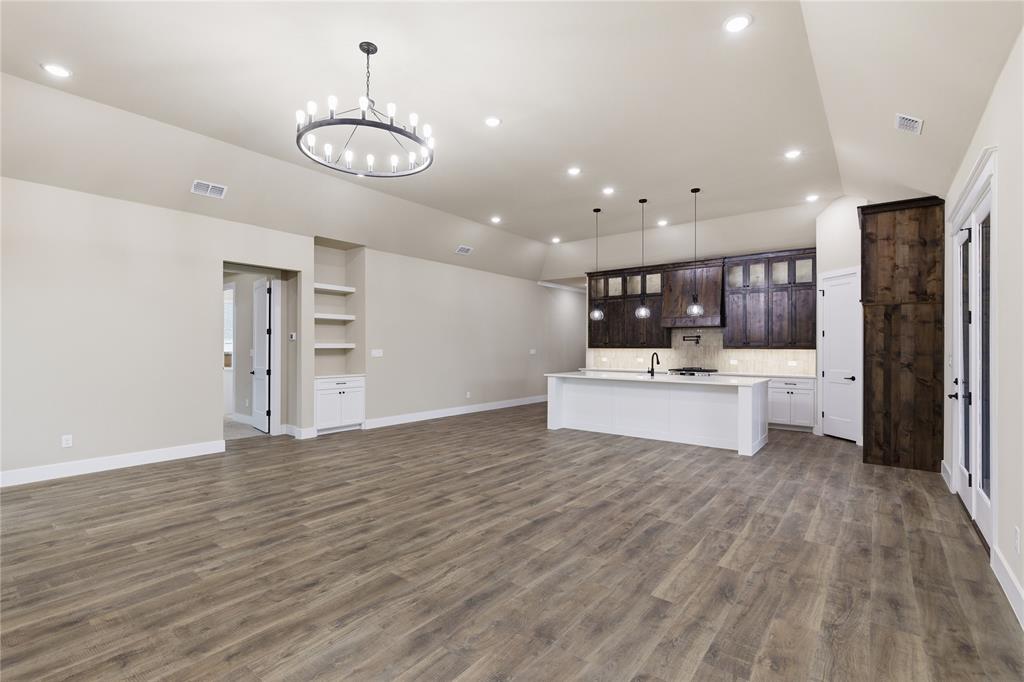 702 Anne Road Van Alstyne, TX 75495 - Photo 9 of 27 Open-concept living area featuring wood-finish flooring, recessed lighting, and a contemporary chandelier