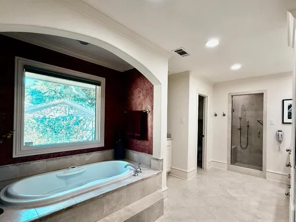 a bathroom with a tub a sink and a large window
