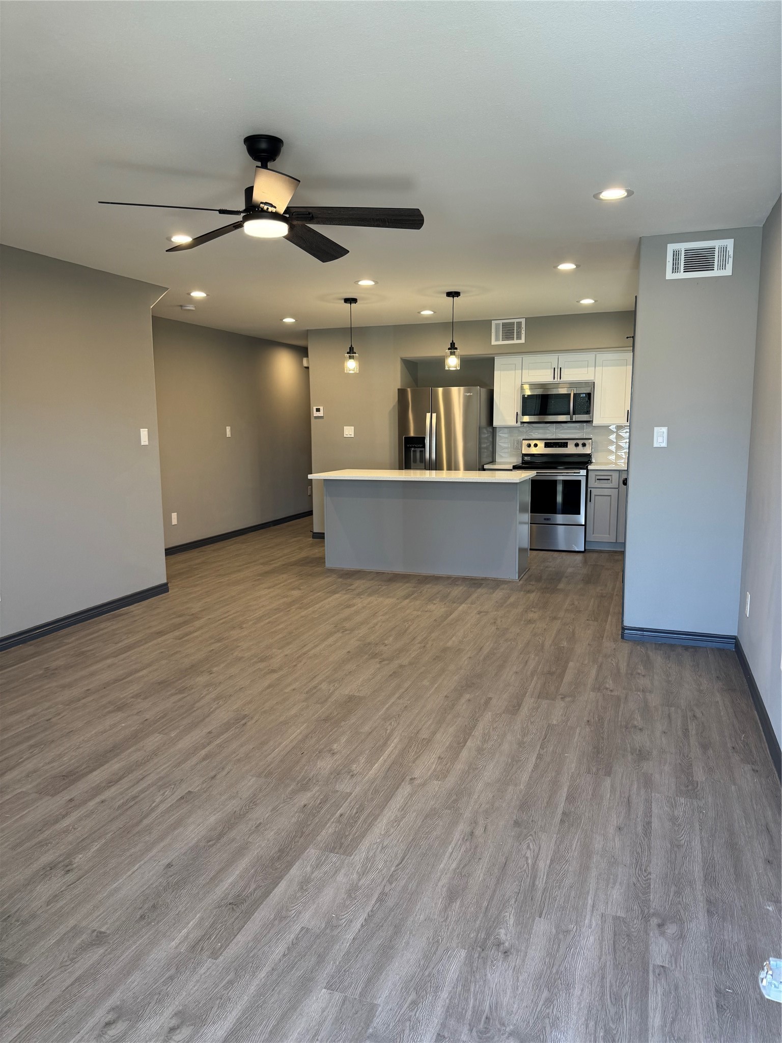 7906 Sexton Street Houston, TX 77028 - Photo 4 of 20 a large kitchen with stainless steel appliances a large counter top a stove and a wooden floor