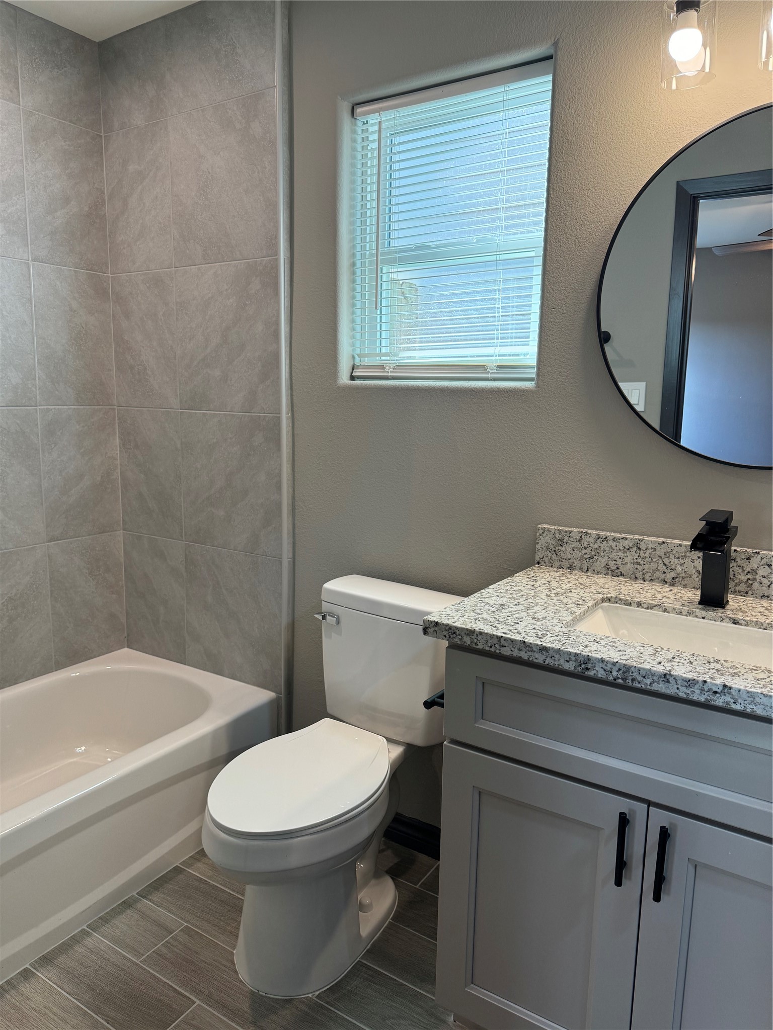 7906 Sexton Street Houston, TX 77028 - Photo 8 of 20 a bathroom with a granite countertop toilet a sink and bathtub
