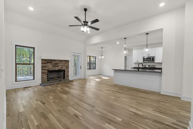 a view of an empty room with a kitchen and a fireplace