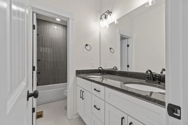 a bathroom with a tub sink and mirror
