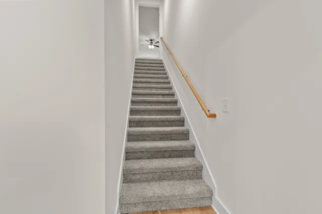 a view of empty room with stairs and fan