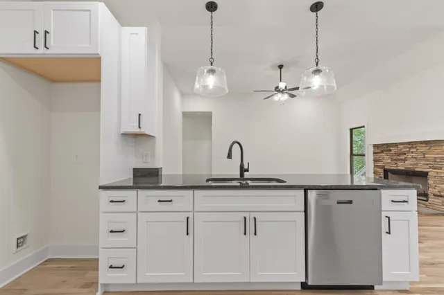a kitchen with white cabinets and chandelier