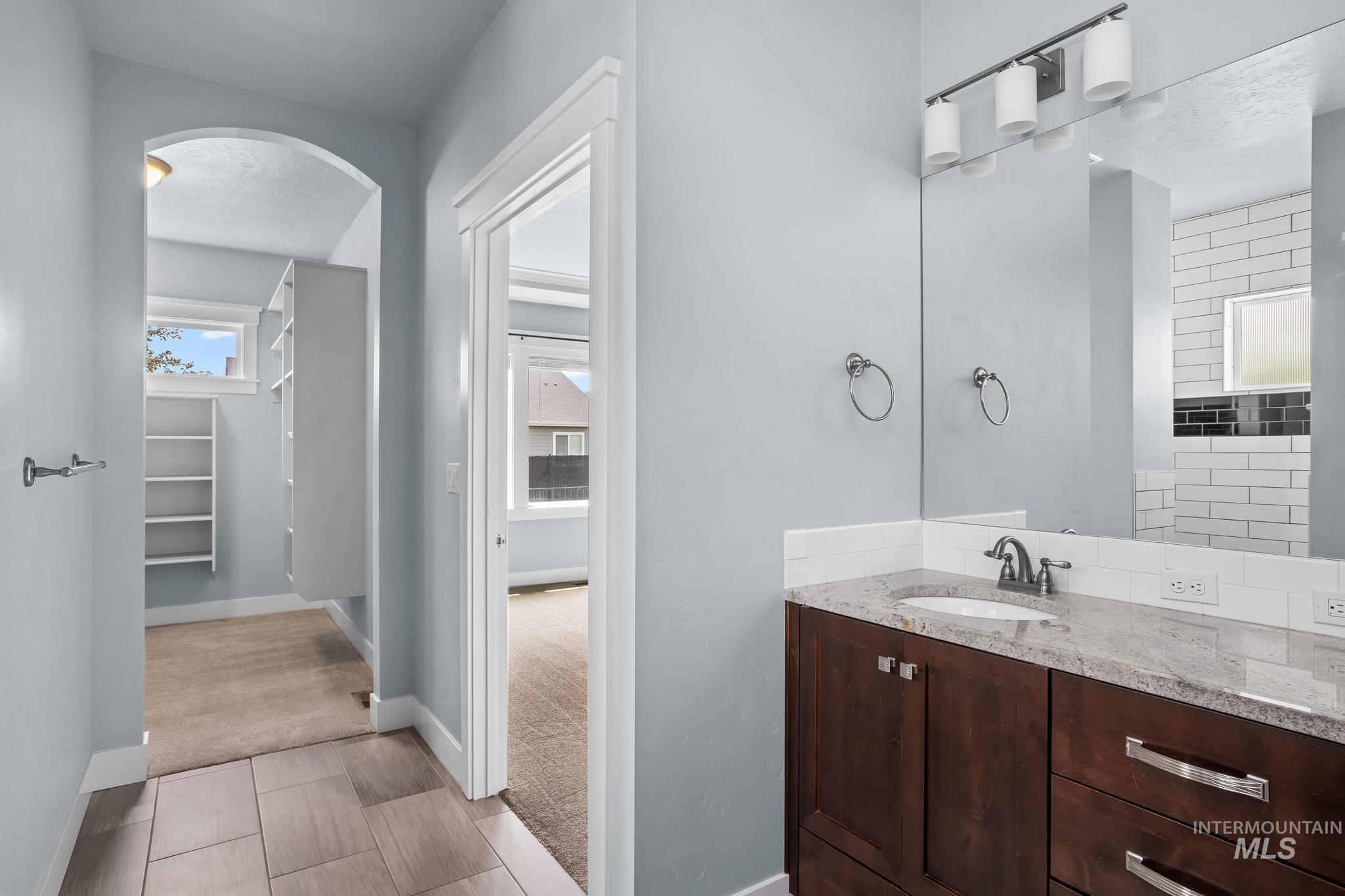 2681 East Rhyolite Court Nampa, ID 83686 - Photo 27 of 48 Bathroom vanity featuring a granite countertop, undermount sink, and wood-finish cabinetry with brushed nickel hardware