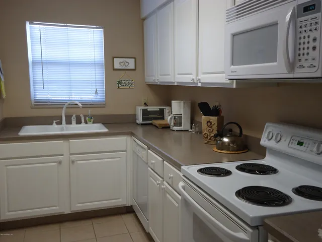 a kitchen with a sink a stove and cabinets