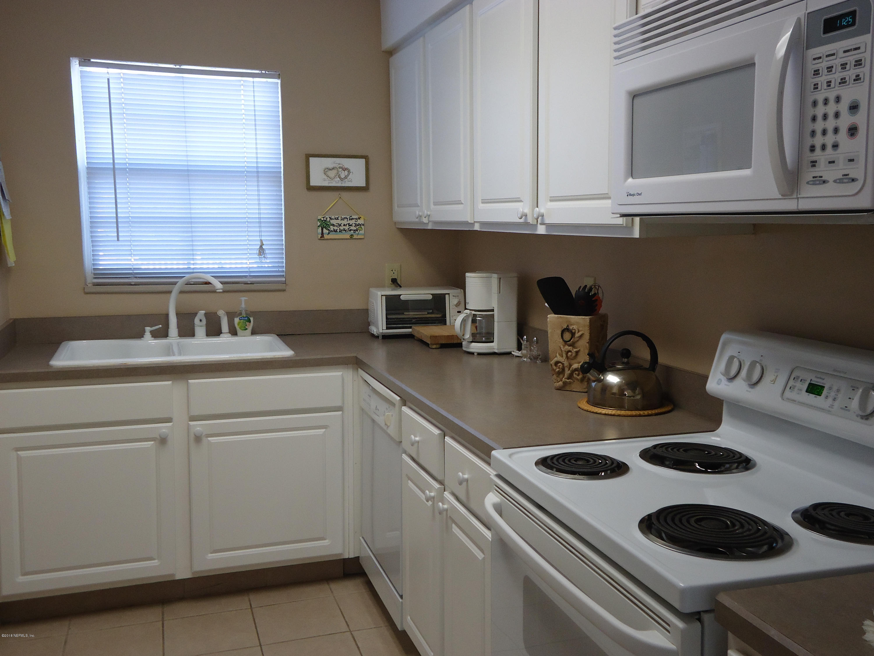 2233 Seminole Road, Unit 39 Atlantic Beach, FL 32233 - Photo 5 of 18 a kitchen with a sink a stove and cabinets