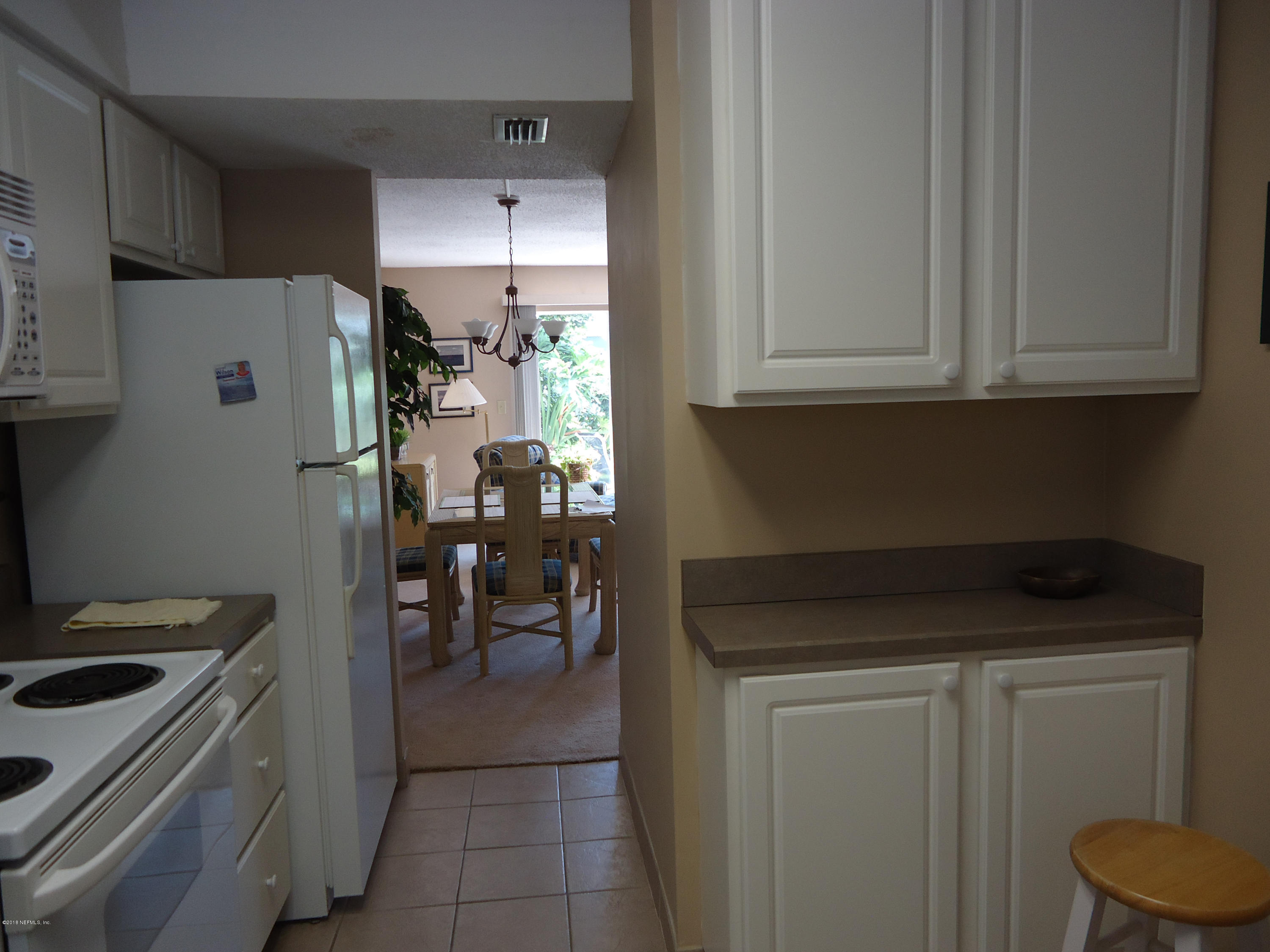 2233 Seminole Road, Unit 39 Atlantic Beach, FL 32233 - Photo 6 of 18 a kitchen with a refrigerator and white cabinets