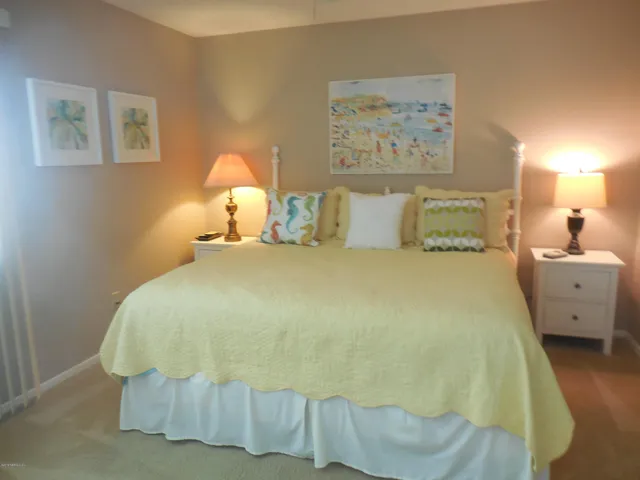 a large bed sitting in a bedroom next to a lamp