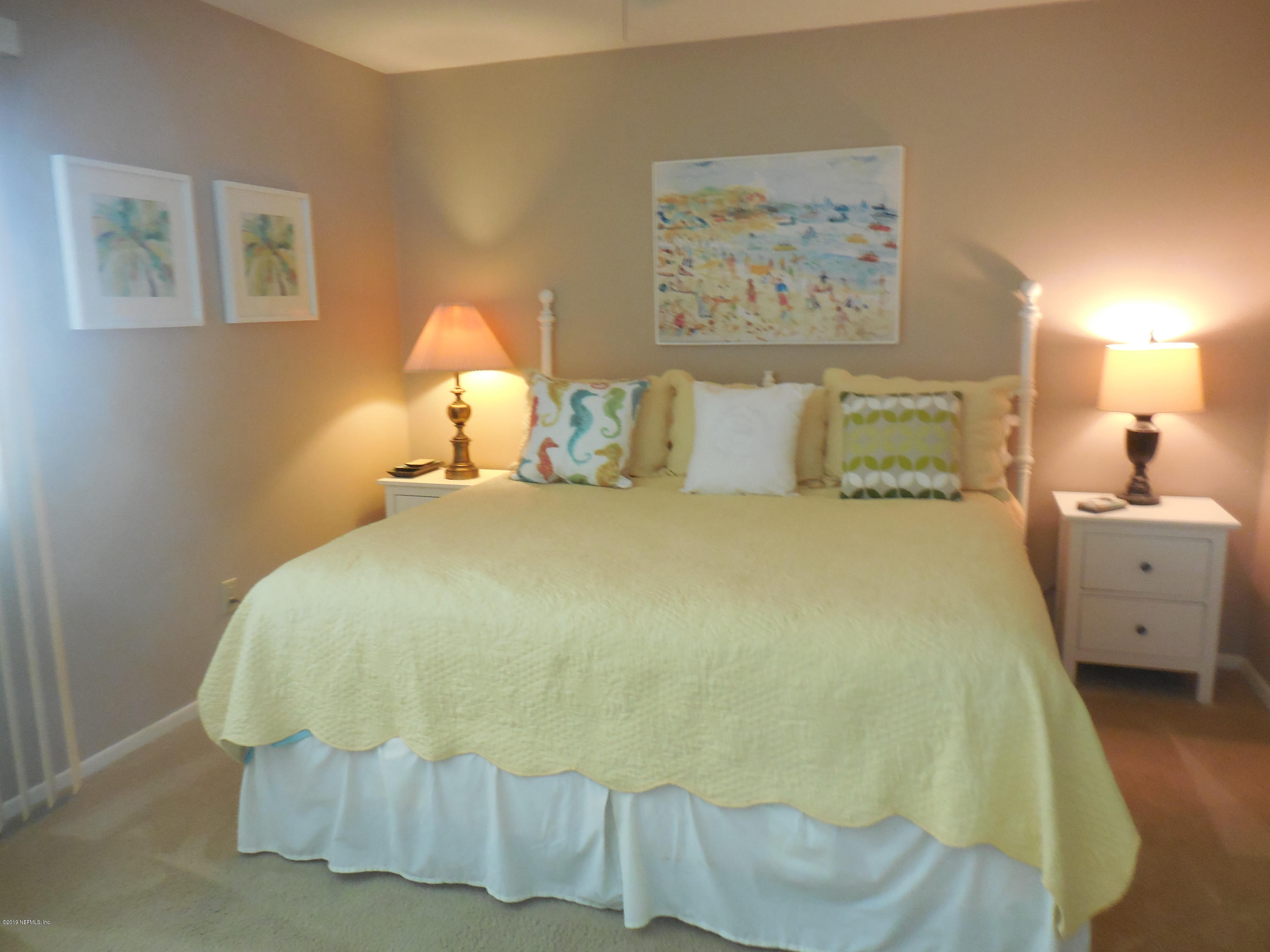 2233 Seminole Road, Unit 39 Atlantic Beach, FL 32233 - Photo 10 of 18 a large bed sitting in a bedroom next to a lamp