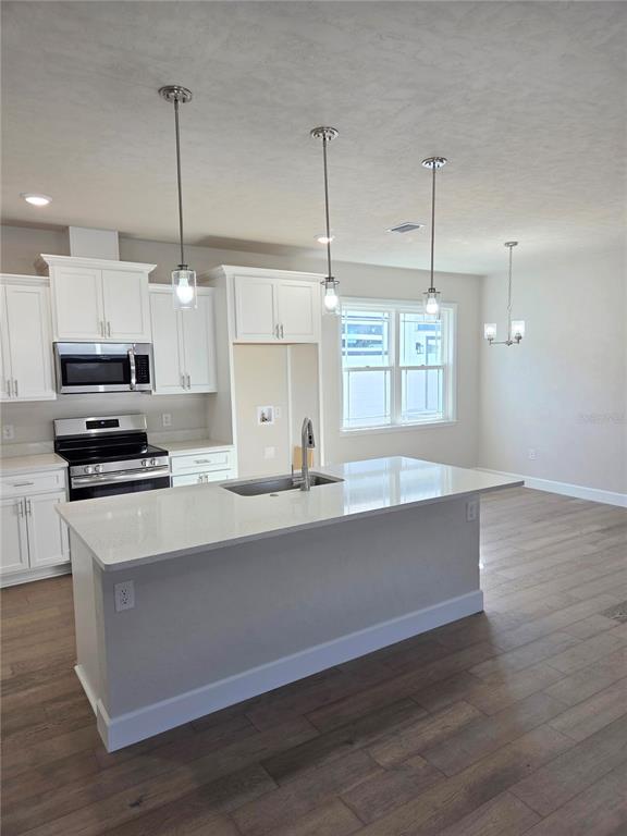 1761 Southwest 244th Way Newberry, FL 32669 - Photo 3 of 21 a large kitchen with stainless steel appliances a large counter top a sink a refrigerator and a window