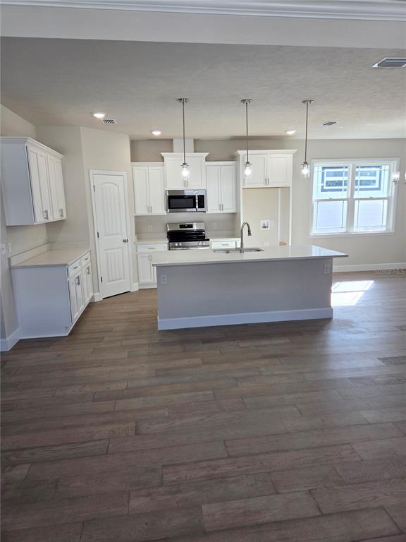 1761 Southwest 244th Way Newberry, FL 32669 - Photo 6 of 21 a large kitchen with stainless steel appliances a large counter top a stove and a refrigerator
