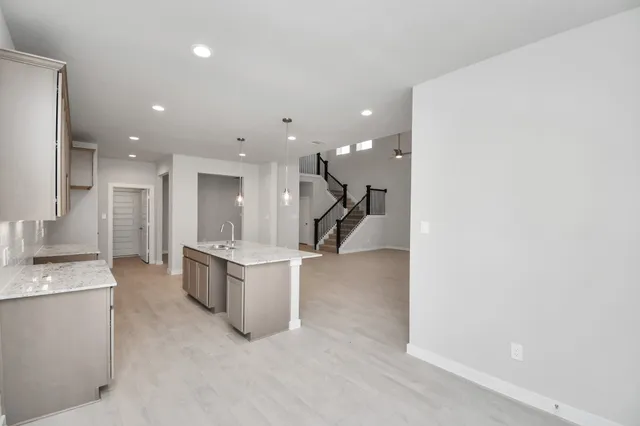 a open kitchen with stainless steel appliances kitchen island a large counter top a stove and a sink